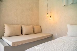 a couch sitting in a room with two beds at Villa Kaitei in São Miguel do Gostoso +32 photos
