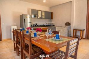 a dining room table with chairs and a kitchen at Villa Kaitei in São Miguel do Gostoso