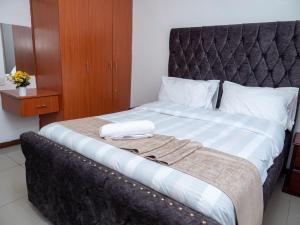 a bed with two towels on top of it at Perfect Palm Condos-P2 in Nakuru +33 photos