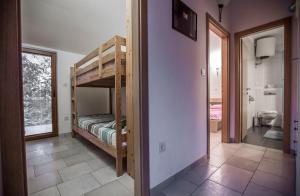 Apartments Villa Kras Krk في مالينسكا: غرفة مع سرير بطابقين وحمام