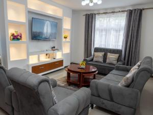 a living room with two couches and a tv at Perfect Palm Condos-P2 in Nakuru