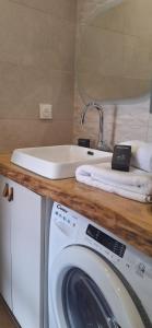 a bathroom with a sink and a washing machine at Studio face plage / centre ville in Arcachon