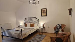 a bedroom with a bed and a chair and a chandelier at Vila Studio Rasnov cu ciubar si sauna in Râşnov