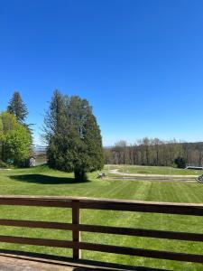 a fence in front of a field with a tree at Skyline Inn in Mount Pocono