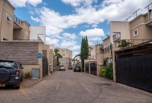 an empty street with buildings and cars parked on it at Perfect Palm Condos-P2 in Nakuru