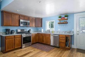 a kitchen with wooden cabinets and stainless steel appliances at Home Squared-Downtown with Fire Pit in Paso Robles