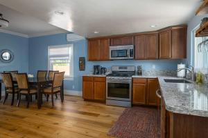 a kitchen with wooden cabinets and a table with chairs at Home Squared-Downtown with Fire Pit in Paso Robles +21 photos