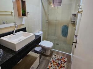 a bathroom with a sink and a toilet and a shower at Apartamento Beira-mar praia centro itapema in Itapema +21 photos