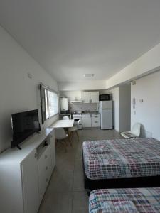 a hotel room with a bed and a kitchen with at Monoambiente Centro in Comodoro Rivadavia
