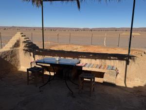 a table and two stools sitting in front of a wall at Guest House For Rent Merzane in Merzane +59 photos