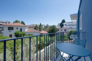 a balcony with a blue table and a building at Secret Garden Studios in Mytilene