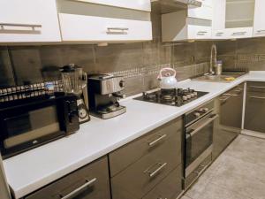 a kitchen with a stove and a microwave at APaRTAMENT MOUTAIN SKY in Świeradów-Zdrój