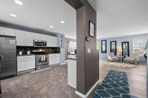 a kitchen with white cabinets and a living room at 1130 Mockingbird St in Brighton