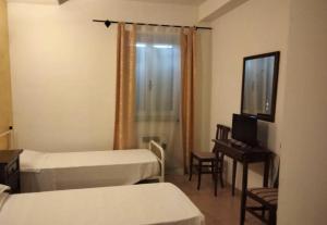 a hotel room with two beds and a television at Albergo Il Pescatore in Trevi