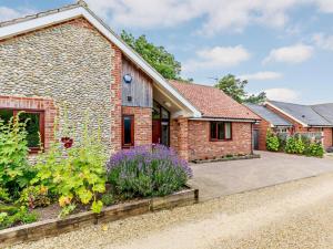 a brick house with a garden in front of it at 3 Bed in Holt oc-83628 in Blakeney
