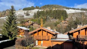 a large log cabin with snow on the mountain at Red Fir Chalet in Megève