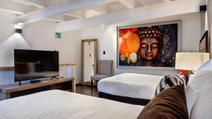 a hotel room with two beds and a tv at Casa Solsticio 212 in Cholula