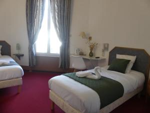 a bedroom with two swans sitting on a bed at Le Renaissance in Montdidier +18 photos