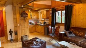 a living room with a couch and a kitchen at Red Fir Chalet in Megève