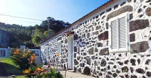 a stone building with a window and a door at Azores Panorama Lodge in Norte Pequeno