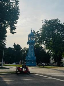 a blue clock tower in the middle of a street at Grey Serenity in Brăila