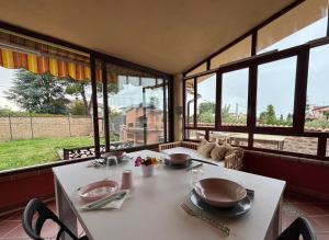 a dining room with a table and some windows at Villa Ninnì in Treglio