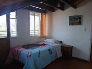 a bedroom with a bed in a room with windows at Maldito Pez Bed & Breakfast in Valparaíso