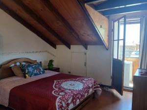 a bedroom with a bed with a red comforter at Maldito Pez Bed & Breakfast in Valparaíso