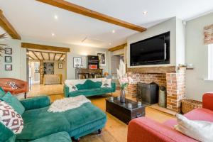a living room with a fireplace and a flat screen tv at 5 Bed in Blofield oc-s33037 in Blofield