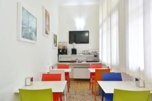 Hotel Trentina في ميلانو: غرفة طعام مع طاولات وكراسي ملونة