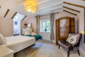 a bedroom with a bed and a chair at 5 Bed in Blofield oc-s33037 in Blofield