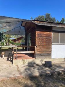 a wooden cabin with a large umbrella in front of it at Hermosa Cabaña en Limache in Lo Narváez