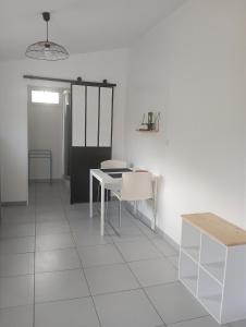 a room with a white table and white chairs at Studio confortable au calme - Terrasse privative in Labergement-Foigney
