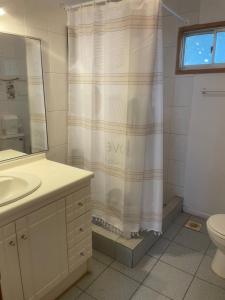 a bathroom with a sink and a shower curtain at Hermosa Cabaña en Limache in Lo Narváez +11 photos