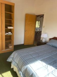a bedroom with a bed and a wooden cabinet at Hermosa Cabaña en Limache in Lo Narváez