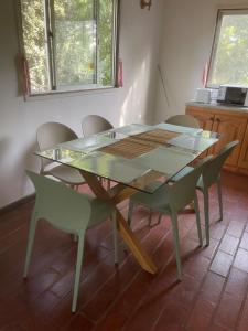 a glass table and chairs in a room at Hermosa Cabaña en Limache in Lo Narváez