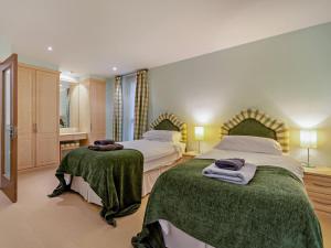 a bedroom with two beds with green blankets at 4 Bed in Windermere oc-95682 in Winster