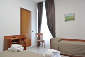 una camera d'albergo con letto e scrivania di Hotel Trentina a Milano