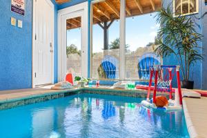 a swimming pool in a house with a blue wall at Afterglow by Ghosal Luxury Lodging in Sevierville