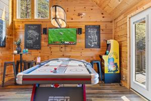 a room with a ping pong table and a tv at Afterglow by Ghosal Luxury Lodging in Sevierville