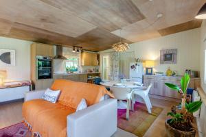 a living room with an orange couch and a kitchen at 1 Bed in South Hams oc-g31078 in Kingston +14 photos