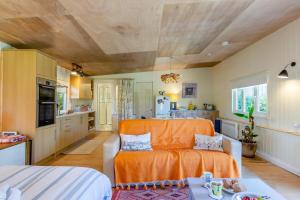 a living room with an orange couch and a kitchen at 1 Bed in South Hams oc-g31078 in Kingston