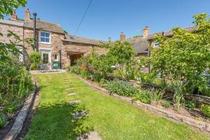 an old stone house with a garden in front of it at 2 Bed in Caldbeck oc-a32049 in Caldbeck