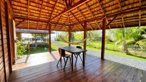 a wooden porch with a table and chairs on it at Lodge ORION - Coté Piscine in Uturoa