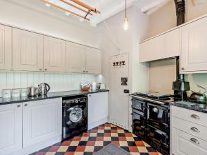 a kitchen with white cabinets and a black dishwasher at 4 Bed in Hope Valley oc-pk939 in Curbar
