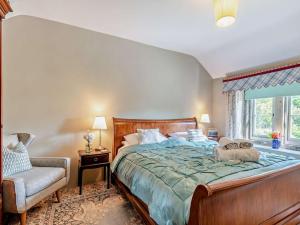 a bedroom with a bed and a chair and a window at 4 Bed in Hope Valley oc-pk939 in Curbar