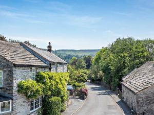 an empty street in a village with houses at 4 Bed in Hope Valley oc-pk939 in Curbar