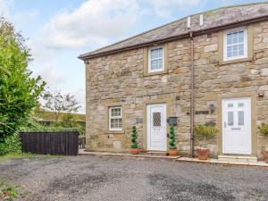 an old stone house with white doors and plants at 3 Bed in Chathill oc-79566 in Beadnell