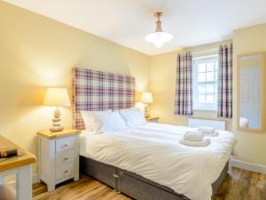 a bedroom with a bed and a window at 3 Bed in Chathill oc-79566 in Beadnell