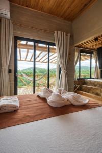 a bedroom with a bed with a large window at Sertão do Luar in Jurubeba +73 photos
